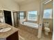 Bright bathroom featuring granite countertops, a corner shower, and a separate soaking tub at 116 Standford Dr, Mcdonough, GA 30252