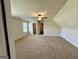 Expansive bonus room featuring neutral carpet, ceiling fan, and an abundance of natural light at 116 Standford Dr, Mcdonough, GA 30252