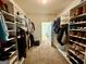 Large walk-in closet with built-in shelving and racks for organized storage, connecting to the bathroom at 116 Standford Dr, Mcdonough, GA 30252