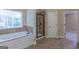 Bright bathroom showcasing a soaking tub beneath a window, and a glass-enclosed shower at 125 Seawright Dr, Fayetteville, GA 30215