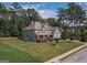 Beautiful two-story home featuring manicured lawn, stone accents, teal siding, and mature trees in a serene neighborhood setting at 125 Seawright Dr, Fayetteville, GA 30215