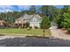 Two-story home with a well-manicured lawn, mature trees, and a long driveway at 125 Seawright Dr, Fayetteville, GA 30215