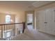 Upstairs hallway with chandelier and staircase and view into a bedroom at 125 Seawright Dr, Fayetteville, GA 30215