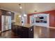 Open kitchen with stainless steel appliances, granite countertops, dark cabinets and island leading to Gathering room at 125 Seawright Dr, Fayetteville, GA 30215