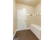 Mudroom with dark wood floors, storage bench, coat hooks, and white door at 125 Seawright Dr, Fayetteville, GA 30215