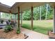 A covered patio with comfortable seating and a ceiling fan, overlooking a large, well-maintained backyard at 125 Seawright Dr, Fayetteville, GA 30215