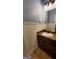 Stylish bathroom with wood vanity, granite countertop, mirror and neutral tile flooring at 90 Alcovy Reserve Way, Covington, GA 30014