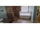 Bathroom with tiled shower and bath, with a large window providing natural light at 90 Alcovy Reserve Way, Covington, GA 30014
