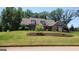 Charming home featuring a lush green lawn with mature trees and beautifully landscaped yard at 90 Alcovy Reserve Way, Covington, GA 30014