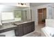 Bathroom featuring granite countertops, tiled floors, soaking tub, and glass shower at 6660 Canyon Cv, Cumming, GA 30028