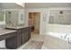 Bathroom with granite countertops, tiled floors, and soaking tub at 6660 Canyon Cv, Cumming, GA 30028