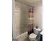 Standard bathroom features a clean tub, shower with patterned curtain, and functional toilet at 6660 Canyon Cv, Cumming, GA 30028