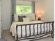 Cozy bedroom with metal frame bed, layered pillows and serene window view at 6660 Canyon Cv, Cumming, GA 30028
