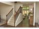 Inviting entryway with staircase, hardwood floors, and view into the naturally lit living room at 6660 Canyon Cv, Cumming, GA 30028
