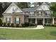 Beautiful two-story home featuring brick and stone accents, a manicured lawn, and a welcoming front porch at 6660 Canyon Cv, Cumming, GA 30028