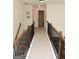 Upstairs hallway with neutral carpet, lighting, and access to several rooms at 6660 Canyon Cv, Cumming, GA 30028