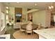 Open-concept living and dining areas featuring a brick fireplace and a view of the kitchen at 6660 Canyon Cv, Cumming, GA 30028