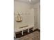 Bright mudroom features a built-in bench with hooks, storage cabinet, and stylish decor at 6660 Canyon Cv, Cumming, GA 30028