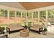 Bright sunroom with multiple windows, comfortable seating, and a view of the yard at 6660 Canyon Cv, Cumming, GA 30028