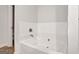 This bright bathroom features a white soaking tub with modern fixtures and half-wall tiling at 1184 Bluecoat Cir # 84, Hampton, GA 30228