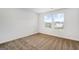 A bedroom with plush carpet and two bright windows showcasing the beautiful exterior view at 1184 Bluecoat Cir # 84, Hampton, GA 30228