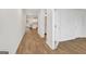 Bright hallway with wood-look floors leads to an open-concept kitchen with modern appliances, granite counters, and ample natural light at 1184 Bluecoat Cir # 84, Hampton, GA 30228