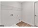 Bright laundry room with wood-look flooring, white walls, and wire shelving and hookups at 1184 Bluecoat Cir # 84, Hampton, GA 30228