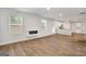 Bright, open living area featuring a modern fireplace, wood-look floors, and seamless transition to the modern kitchen at 1184 Bluecoat Cir # 84, Hampton, GA 30228