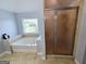 Bathroom featuring soaking tub near a window and a separate tiled shower with a decorative glass door at 206 Birchin Dr, Woodstock, GA 30188