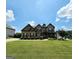 Stunning two-story stone home with a manicured lawn and inviting front porch at 206 Birchin Dr, Woodstock, GA 30188