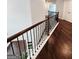 Hallway with hardwood floors and a wood and iron banister leading to a second floor at 206 Birchin Dr, Woodstock, GA 30188