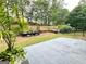 Spacious backyard featuring a concrete patio, landscaping, and a charming black fence at 121 Pinnacle Ln, Mcdonough, GA 30253