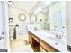 Bright bathroom with a large mirror, double sink vanity, and a separate bathtub and toilet area at 121 Pinnacle Ln, Mcdonough, GA 30253