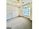 Sunny bedroom offers a ceiling fan, large window, and neutral carpeting at 121 Pinnacle Ln, Mcdonough, GA 30253