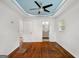 Bedroom with hard wood floors, ceiling fan and blue painted tray ceiling, leading into the bathroom at 1675 Brewer Sw Blvd, Atlanta, GA 30310
