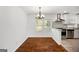 Cozy dining area with hardwood floors, chandelier, and view into the bright, renovated kitchen at 1675 Brewer Sw Blvd, Atlanta, GA 30310