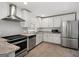A well lit kitchen with stainless steel appliances, granite counter tops and light tile flooring at 1675 Brewer Sw Blvd, Atlanta, GA 30310