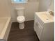 Bathroom featuring sleek vanity, toilet, and dark wood-look flooring at 212 Rockmart Rd, Villa Rica, GA 30180