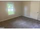 Bright bedroom featuring neutral walls, plush carpeting, and a window for natural light at 212 Rockmart Rd, Villa Rica, GA 30180