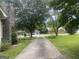 View down long driveway, trees and cozy house on right and other houses in back at 212 Rockmart Rd, Villa Rica, GA 30180