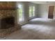 Spacious living room featuring a stone fireplace, neutral paint, new carpet, and natural light at 212 Rockmart Rd, Villa Rica, GA 30180