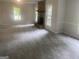 Large living room featuring stone fireplace, neutral paint, new carpet, and bright, natural lighting at 212 Rockmart Rd, Villa Rica, GA 30180