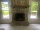 Living room showcases stone fireplace with mantle, neutral paint, new carpet, and bright windows at 212 Rockmart Rd, Villa Rica, GA 30180