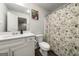 Well-lit bathroom features a white vanity, toilet and shower with floral curtain at 8717 Lakeview Commons, Jonesboro, GA 30238