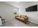 Cozy secondary bedroom featuring a tan sofa and a mounted television at 8717 Lakeview Commons, Jonesboro, GA 30238