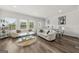 Bright and airy living room with modern furniture, wood floors, and ample natural light at 8717 Lakeview Commons, Jonesboro, GA 30238