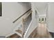 Bright stairway showcasing wood-look floors and carpeted stairs with wrought iron spindles at 8717 Lakeview Commons, Jonesboro, GA 30238