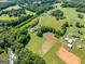 Serene aerial view of a property with lush greenery, a winding driveway, and open fields at 226 Euharlee Five Forks Rd, Kingston, GA 30145