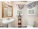 Traditional bathroom featuring pedestal sink, decorative window, and neutral color palette at 226 Euharlee Five Forks Rd, Kingston, GA 30145