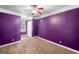 A cozy bedroom featuring neutral carpet, a ceiling fan, and bright purple walls at 226 Euharlee Five Forks Rd, Kingston, GA 30145